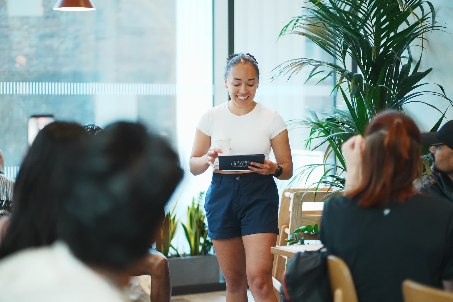An Impacclub host presenting to a seated group at an indoor session
