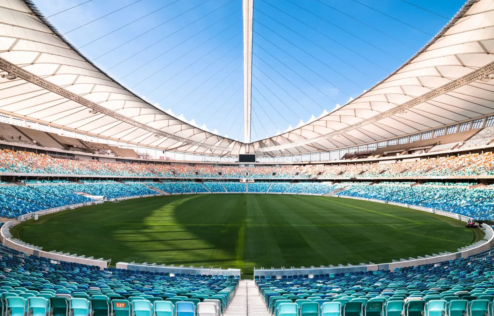Interior of a large football stadium with an empty pitch